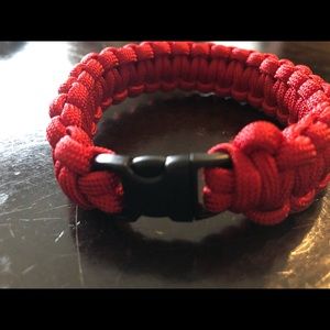 A red paracord rope bracelet about 9-10 “in” long
